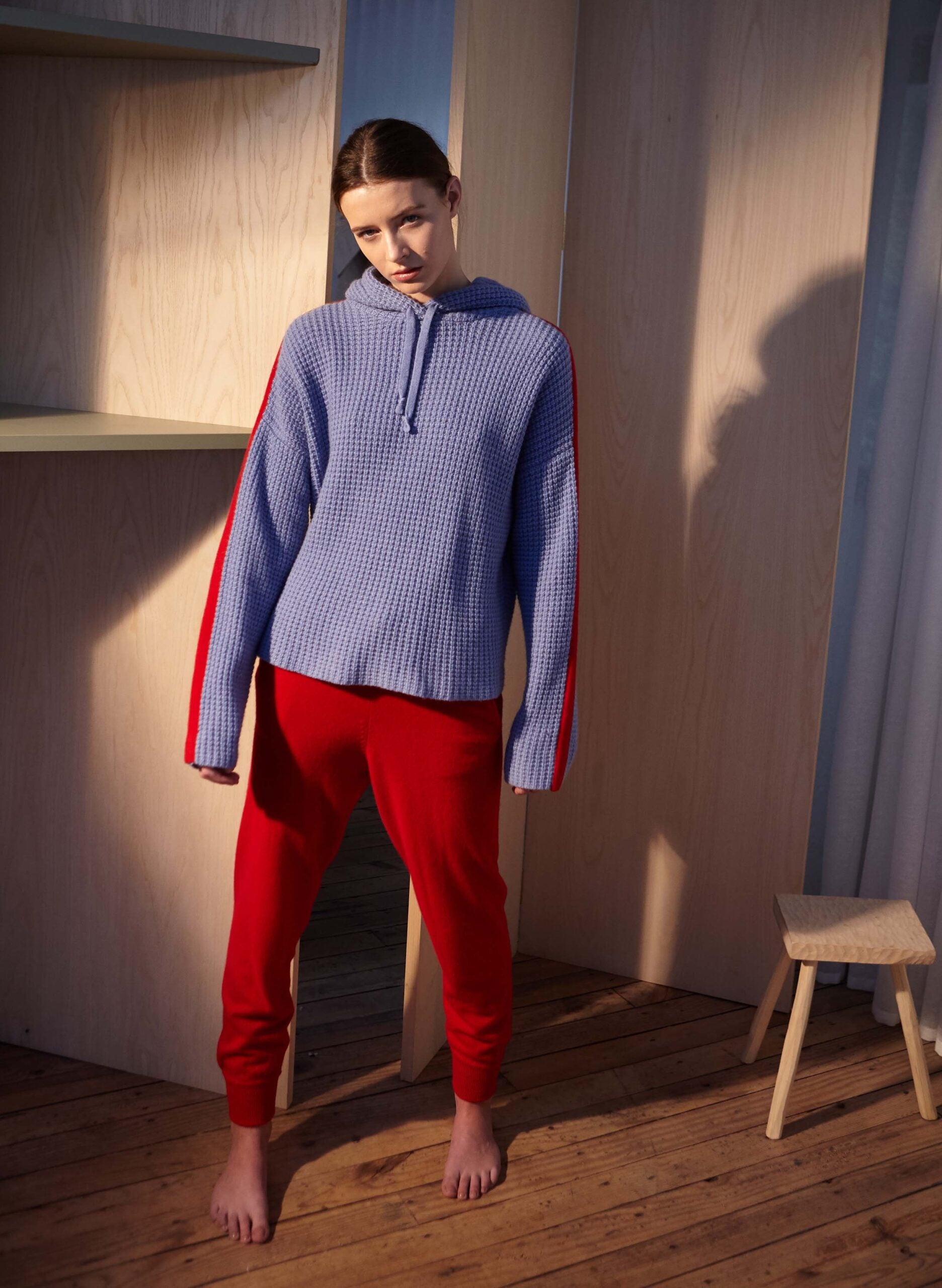 Model wearing purple sweatshirt and red track pants